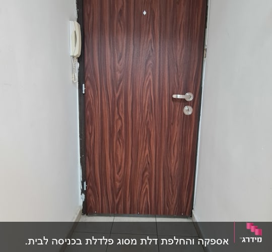 דלת עץ חומה עם ידית כסופה וקיר לבן